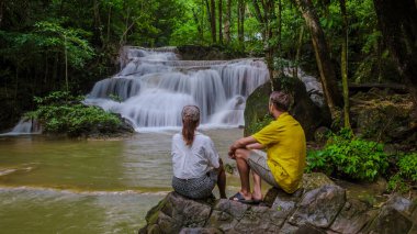 Erawan Şelalesi Tayland Kachanaburi, Tayland 'da güzel bir orman şelalesi. Ulusal Park 'ta Erawan Şelalesi. Orman ve şelalelerle doğa gezisine çıkmış birkaç erkek ve kadın.