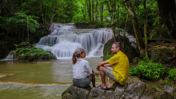 Erawan Waterfall Thailand, a beautiful deep forest waterfall in Thailand. Erawan Waterfall in National Park. a couple of men and women on a trip visiting nature with forest and waterfalls