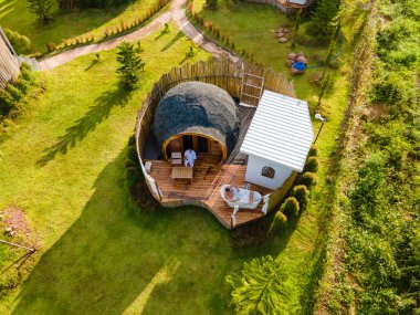 Tatil sırasında Kuzey Tayland dağlarında kamp yapan bir çift kadın ve erkek. Gün batımında dağlarda bir igloo kulübesinde banyo ve küvet. İnsansız hava aracı görüntüsü