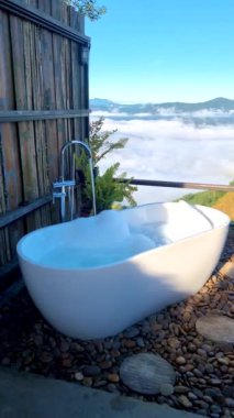 Tatil sırasında Chiang Rai Kuzey Tayland dağlarına bakan küvet. Açık banyo, gün batımında Doi Chang dağında sisli ve sisli bir küvet.