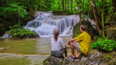 Erawan Şelalesi Tayland Kachanaburi, Tayland 'da güzel bir orman şelalesi. Ulusal Park 'ta Erawan Şelalesi. Orman ve şelalelerle doğa gezisine çıkmış birkaç erkek ve kadın.
