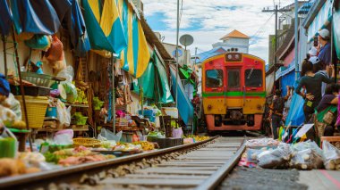 Maeklong Demiryolu Tayland Pazarı, Tren Yolda Yavaş Gidiyor. Demiryolu Pisti 'ndeki Şemsiye Taze Pazarı, Mae Klong Tren İstasyonu, Bangkok, Tayland' da ünlü bir demiryolu pazarı.
