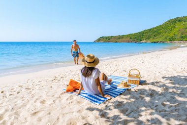 Birkaç erkek ve kadın yaz tatilinde Pattaya Tayland yakınlarındaki Koh Larn Tayland 'da, berrak su okyanusu olan beyaz bir plajda tatildeler. Tropik Ada