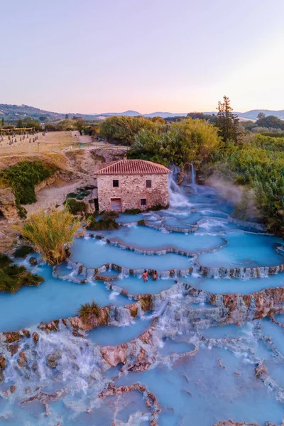 Toscane Italy, natural spa with waterfalls and hot springs at Saturnia thermal Baths, Grosseto, Tuscany, Italy men and woman at the Natural thermal waterfalls couple at vacation at Saturnia Tuscany