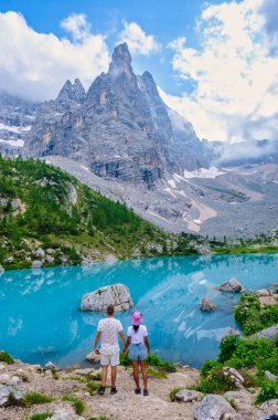 İtalyan Dolomitleri 'nde Lago di Sorapis, sütlü mavi göl Lago di Sorapis, Sorapis Gölü, Dolomitler, İtalya yaz aylarında İtalyan dağlarında yürüyüş yapan çiftler.