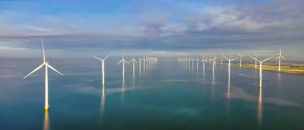Windmill turbines at sea seen from a drone aerial view from above at a huge windmill park in the Netherlands at the Noordoostpolder in Flevoland