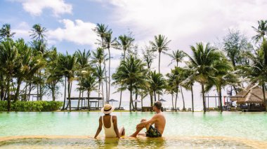 Tayland ormanlarında yüzme havuzu, Tayland ormanlarında yüzme havuzu. Güneşli bir günde güneşli bir günde havuzda tatil sırasında yüzme havuzunda dinlenen iki erkek ve kadın. 