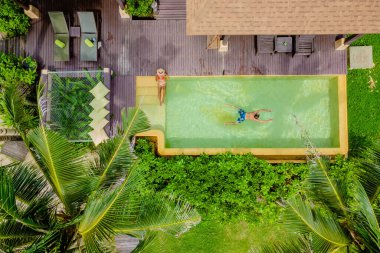 Modern yüzme havuzlu bir ev, sahilde modern bir havuz villası Tayland 'da lüks bir villa, Tayland' da balayında lüks bir tatil yapan bir çift erkek ve kadın. 