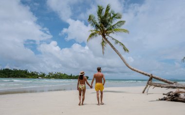 Tayland 'da balayı sırasında Koh Kood Adası' nda el ele tutuşan bir çift erkek ve kadın.