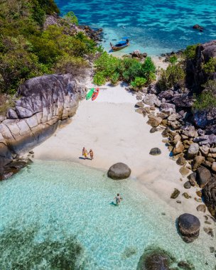 Koh Lipe Adası 'nın güneyindeki Kla Adası sahilinde turkuaz renkli okyanuslar ve Ko Lipe Adası sahilinde kayak yapan beyaz kumlu bir kumsal.