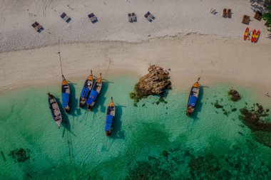 Koh Lipe Adası Güney Tayland Turkuaz renkli okyanusları ve Ko Lipe 'de beyaz kumlu plajları var. Kumsaldaki uzun kuyruklu tekneler güneşli bir günde İHA görüntüsünden görülebiliyor.