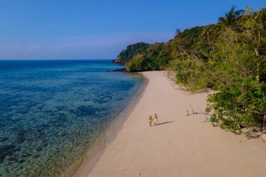  Tayland 'ın Koh Kradan adasında tatil balayı tatili sırasında Güney Tayland' da bir çift kadın ve erkek. Güneşli bir günde Tayland 'da tropik bir plajın insansız hava aracı görüntüsü