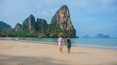 Railay Krabi Tayland sahillerinde el ele yürüyen çok ırklı bir çift.