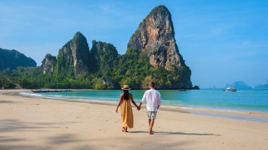 Birkaç erkek ve kadın, Tayland 'da tatilin ilk günlerinde Railay Beach Krabi Tayland sahilinde yürüyorlar. Plaj tatili