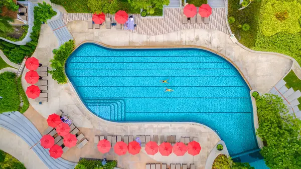 view from above at a couple swimming in an infinity pool on a luxury vacation in Thailand, man and woman in a pool of a luxury hotel in Thailand on vacation, drone aerial view