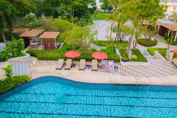 view from above at a couple swimming in an infinity pool on a luxury vacation in Thailand, man and woman in a pool of a luxury hotel in Thailand on vacation, drone aerial view