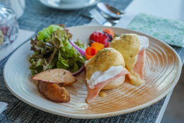 Tayland 'da lüks bir otelde kahvaltıda haşlanmış yumurta, jambonlu yumurta ve holandaise soslu Benedict.