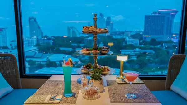rooftop bar in Pattaya Thailand with cocktails and snacks by the window looking out over the city in the evening in Pattaya Thailand