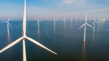 Hollanda 'da mavi gökyüzü yeşil enerji kavramına sahip elektrik üreten yel değirmeni türbinleri