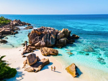 Anse Cocos plajı, La Digue Adası, Seyşeller, La Digue Seyşeller 'in kuş bakışı görüntüsü. Tropikal adada, birkaç erkek ve kadın lüks bir tatil sırasında sahilde yürüyorlar.