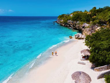 Playa Kalki Curacao Karayip Denizi 'ndeki tropikal ada, Curacao Karayipleri' nin batı yakası Hollanda Antilleri 'nin mavi okyanusu, kumsaldaki kadın ve erkeklerin insansız hava aracı manzarası.