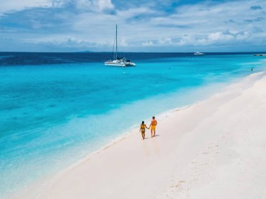 Curacao Karayip Adası, beyaz bir sahil ve turkuvaz renkli okyanusla Little Curacao Adası 'na tekne gezisi sırasında beyaz tropikal bir plajda birkaç erkek ve kadının Drone hava görüntüsü.