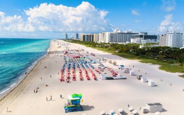 Miami South Beach Florida 'da insansız hava aracı görüntüsü. Renkli sandalyeleri ve şemsiyeleri olan plaj Miami Florida 'nın en iyi insansız hava aracı manzarası.
