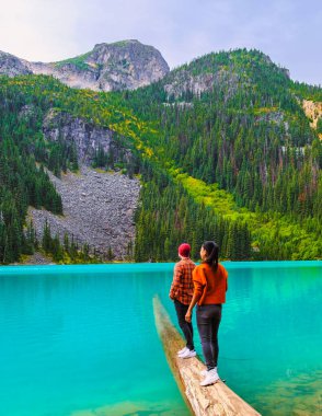 Joffre Lakes British Colombia Whistler Canada, Kanada 'daki Joffre Lakes Ulusal Parkı' nın mavi renkli gölü. Bir çift Asyalı kadın ve Kafkasyalı erkek BC Jofre Gölü 'nde yürüyorlar.