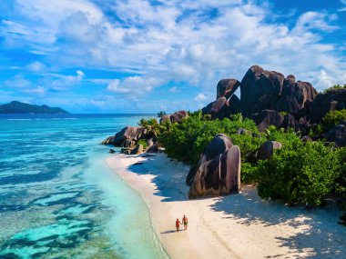 Anse Source d 'Argent, La Digue Seychelles, Seyşeller' de lüks bir tatil sırasında tropik bir plajda iki genç erkek ve kadın.