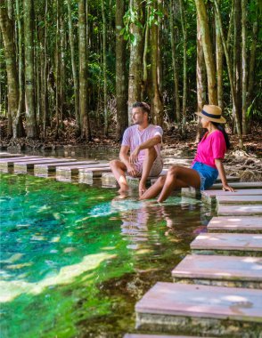 Bir çift erkek ve kadın Zümrüt Havuzu 'nu ve Krabi Tayland' daki Mavi Gölet 'i, ağaçlı bir milli parktaki tropikal lagünü ve kristal berrak suyu olan mangrovları ziyaret ediyor.