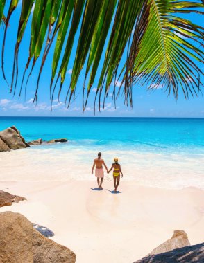 Seyşeller 'de tatilde olan yetişkin bir çift Anse Lazio Praslin Seyşeller' in tropik plajını ziyaret ediyor..