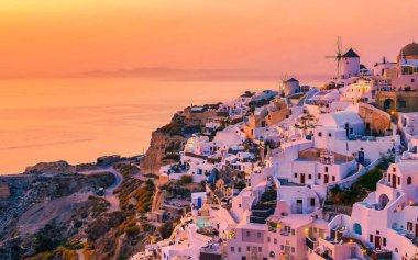 Yunanistan 'ın Oia Santorini köyünde yaz boyunca beyazlatılmış evler ve kiliselerle gün batımı, Yunan Adası Ege Kiklad Adaları