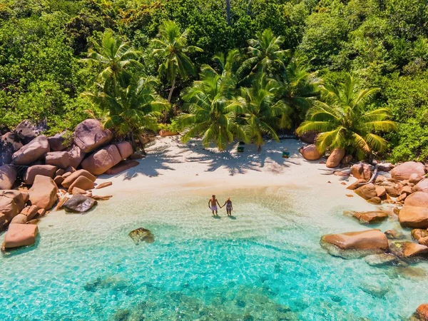 在塞舌尔参观热带海滩Anse Lazio Praslin Seychelles的一对男女游客 海滩上清澈碧绿的大海和棕榈树下的男男女女 — 图库照片