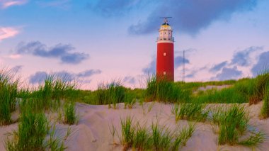 Teksas deniz feneri gün batımında Hollanda Hollanda 'nın sahilinde yaz aylarında Wadden Adası' nda kum tepeleri ile birlikte.