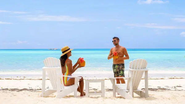 在塞舌尔的一个豪华度假中 一对夫妇在日落时分在海滩上喝鸡尾酒 — 图库照片
