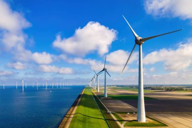 Mavi gökyüzü olan yel değirmeni türbinleri parkı ve okyanusta yel değirmeni türbinleri. Hollanda Avrupa, Hollanda 'nın en büyük rüzgar parkı.