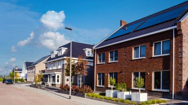 Çatıya güneş panelleri takılı yeni evler, çatıdaki siyah güneş fotovoltaik panelleri, Hollanda 'daki yeşil enerji geçişi, güneş enerjisi