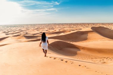 Dubai tatlı kumulları, Dubai çöl safarisinde Asyalı kadın, Birleşik Arap Emirlikleri tatili, Dubai 'de kadın tatili.