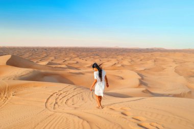 Dubai çöl kum tepeleri, Dubai çölündeki Asyalı kadın safari, Birleşik Arap Emirlikleri tatili, Dubai 'deki kum tepelerinde yürüyen kadın tatili.