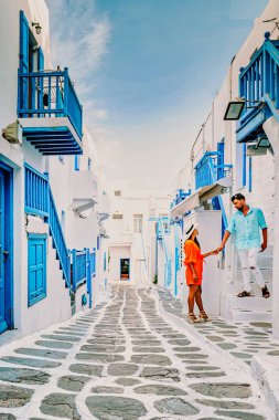 Mykonos Yunanistan, Yunan Adası Mykonos 'ta tatil yapan bir çift erkek ve kadın, Yunanistan' ın Küçük Venedik Mikonos Yunanistan 'ının beyazlatılmış sokaklarında giyinmiş bir kız.
