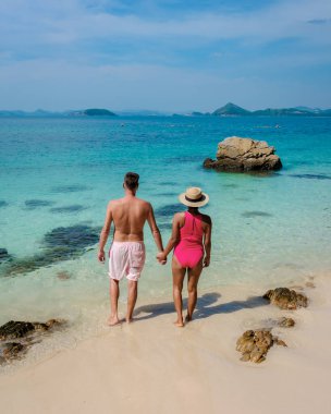 Bir çift Avrupalı erkek ve bir Asyalı kadın Ko Kham Adası Sattahip Chonburi Samaesan Tayland 'a tekne gezisine gittiler. Turkuaz renkli oktanlı bir tropikal adada kadın ve erkek.