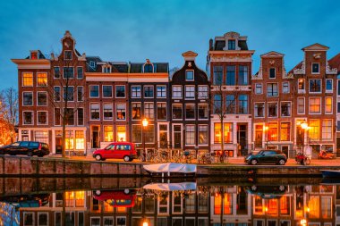 Günbatımında Amsterdam Kanalı, Amsterdam Kanalı köprüsü ve tarihi şehir merkezinde eski tarihi evler.