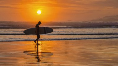 Tofino Sahili Vancouver Adası Pasifik kıyıları gün batımında sörf tahtasıyla gün batımında Tofino sahilinde sörfçüler, siluet Kanada Vancouver Adası Tofino Long Beach sörfçüleri