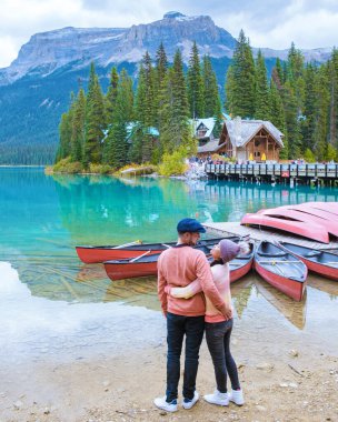 Emerald Lake Yoho Ulusal Parkı Kanada İngiliz Kolombiyası. Birkaç erkek ve kadın göl kenarında kollarını kavuşturmuş Yoho Nationa Park Kanada dağlarına bakıyorlar.