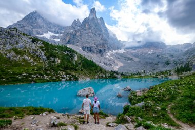 Birkaç erkek ve kadın yaz tatillerinde İtalyan Dolomitleri 'ndeki Lago di Sorapis' i, süt mavisi Lago di Sorapis Gölü 'nü veya İtalya' daki Sorapis Dolomites Gölü 'nü ziyaret etti..