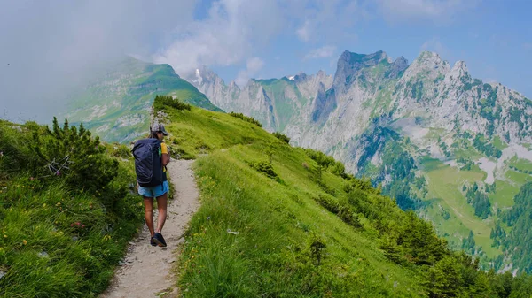 夏休み中にスイスアルプス山脈でハイキングするアジア人女性とバックパックとハイキングブーツ 夏の間 スイスのサクサー ルークの道を歩いている女性 — ストック写真