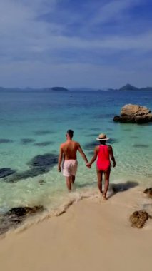 Bir çift Avrupalı erkek ve Asyalı bir kadın güneşli bir günde turkuaz renkli okyanusları olan Ko Kham Adası Sattahip Chonburi Tayland 'a tekne gezisine gittiler.