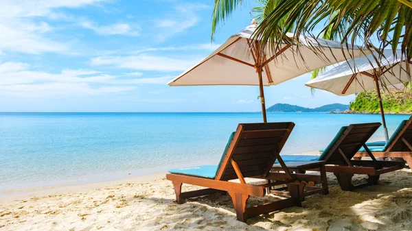 在佐米岛的白色热带海滩上 有一张带遮阳伞的海滩椅 上面有一个草皮色的海洋 — 图库照片