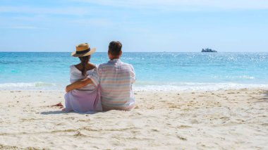 İki erkek ve kadın sahilde oturmuş Koh Samet Adası Rayong Tayland okyanusunu izliyorlar..