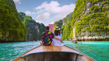 Tatil sırasında Koh Phi Phi Tayland gölünde uzun kuyruklu teknenin önündeki çift. yeşil mavi turkuaz renkli Koh Phi Tayland okyanusu